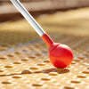 Red rollerball tip of all-terrain cane on yellow tactile pavement
